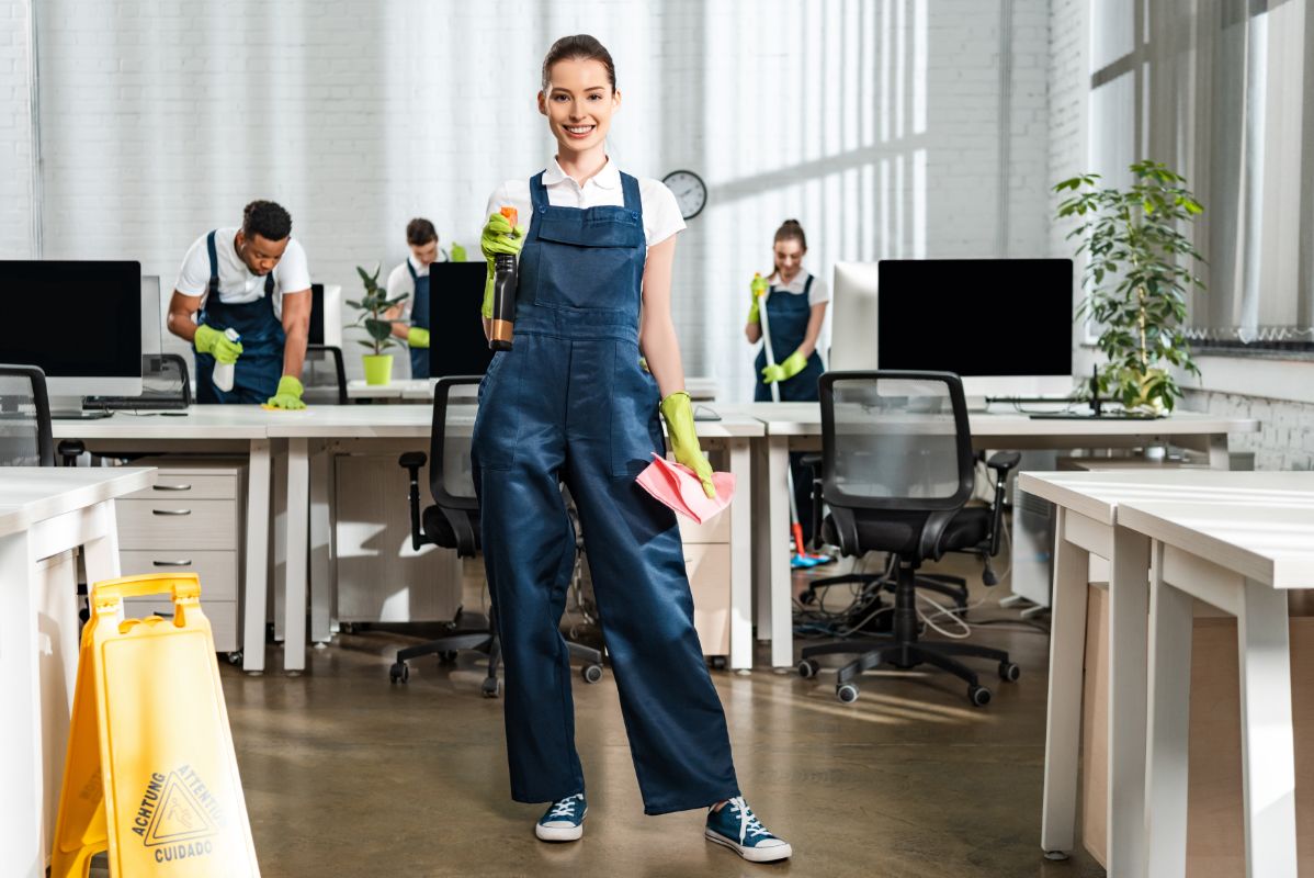 woman smiling with cleaning products in an office 2026 01 06 00 47 18 utc